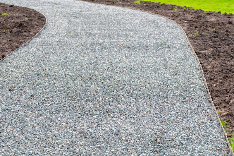 Stone gravel evenly spreaded across a dirveway 