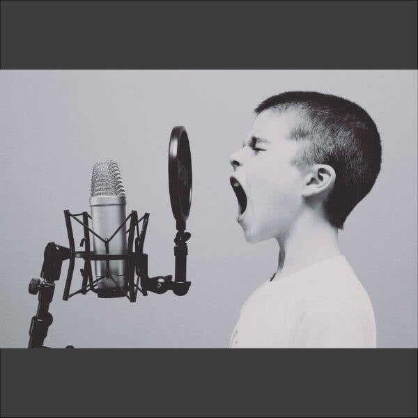 jongetje zingt of schreeuwt microfoon