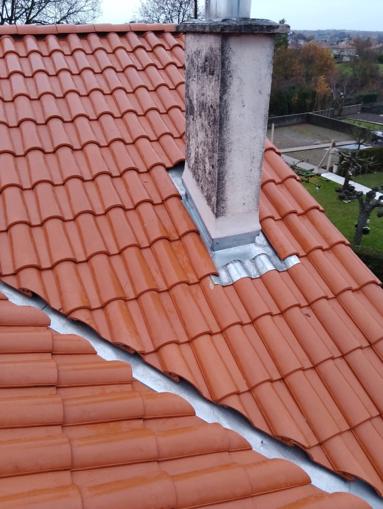 alt="Rénovation complète de toiture en tuiles Romane Évolution avec noue en zinc et entourage de cheminée en zinc sur mesure à Angoulême Charente 16 par Sud-Ouest Couverture"