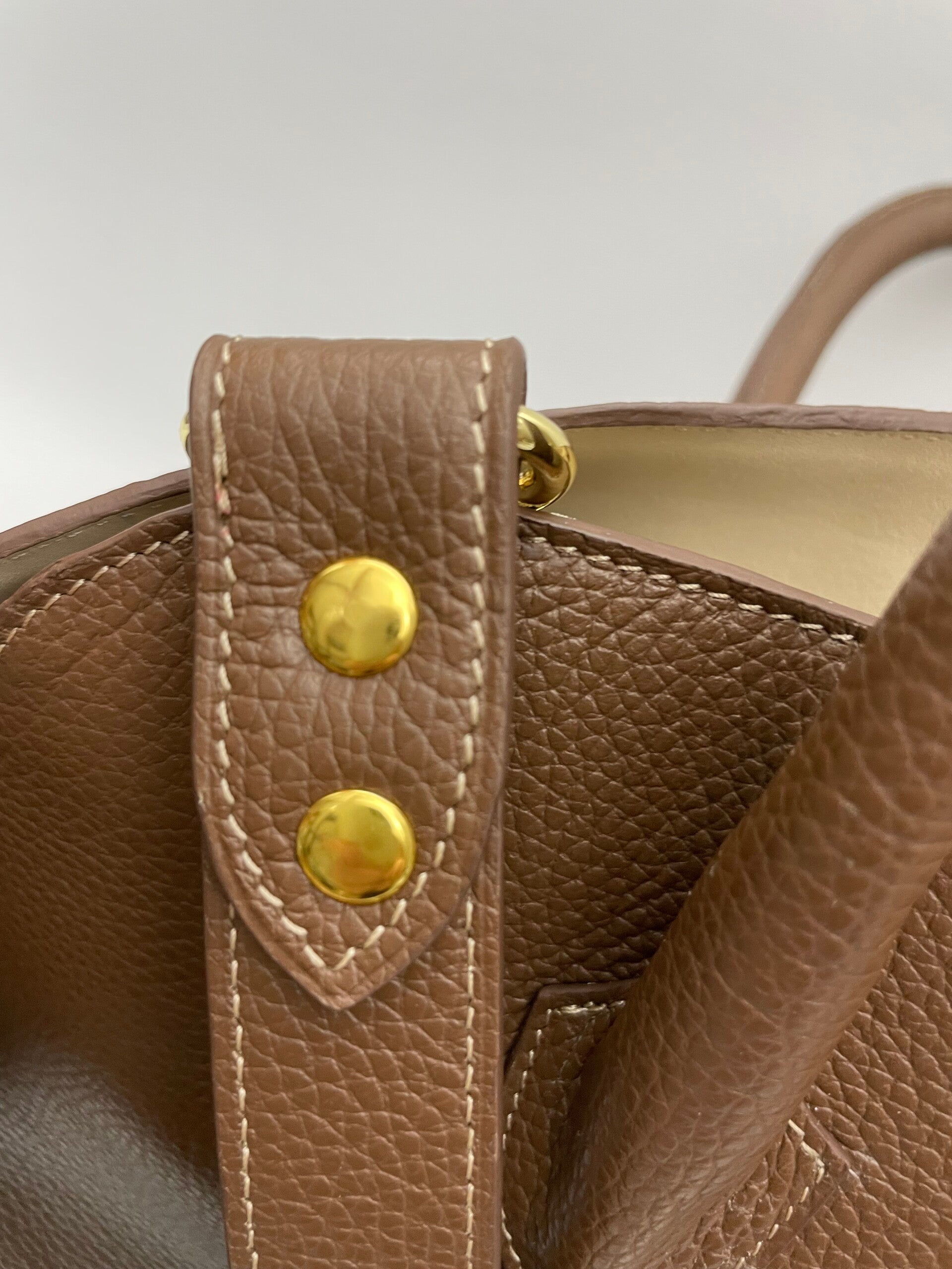 Detail van draagriembevestiging op middenbruin leren shopper
