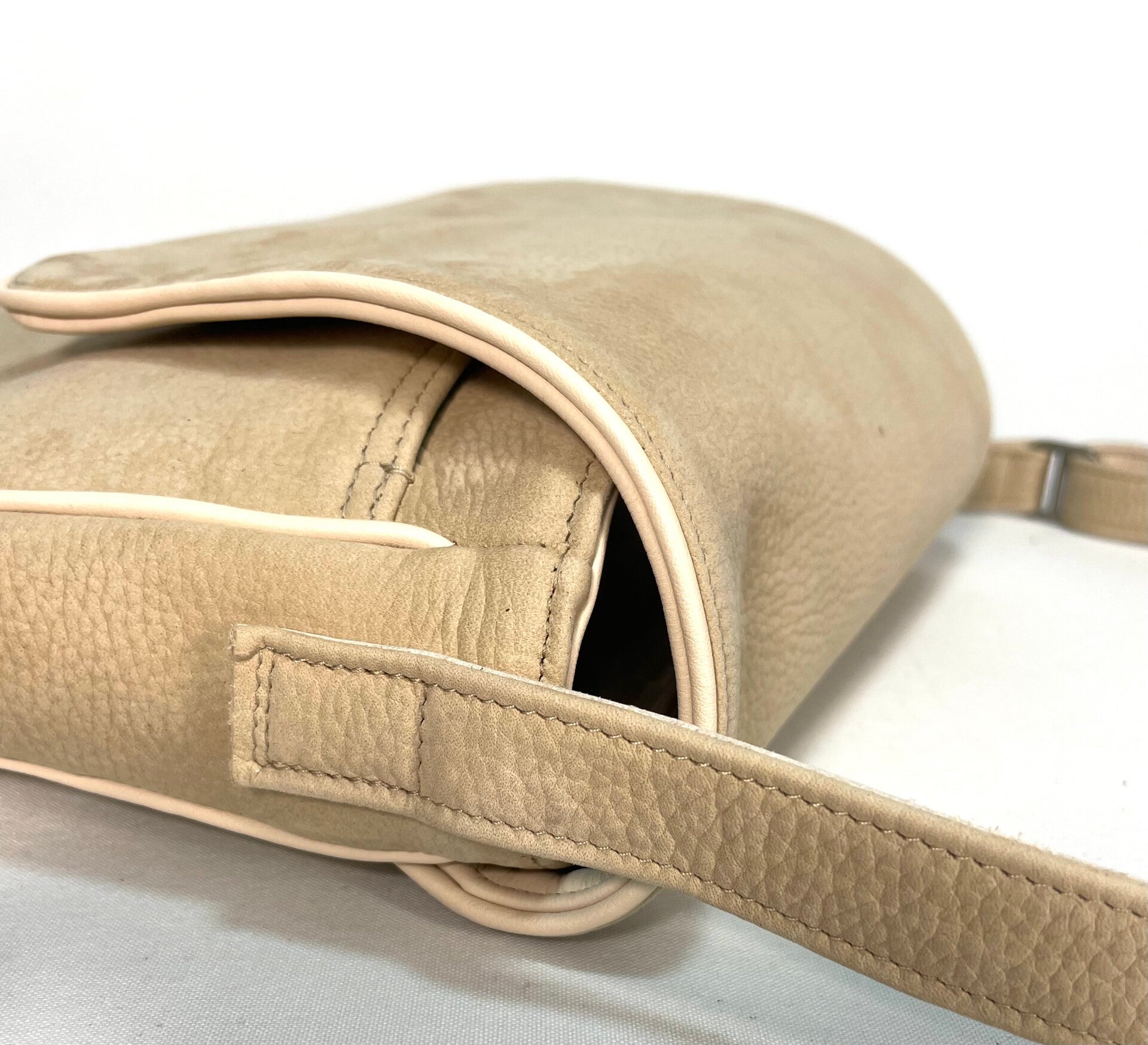Detail van schouderriem en zijkant van geschuurde leren tas