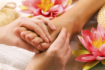 Massaggio ai piedi o foot massage eseguito ad un piede con olio e unguento profumato