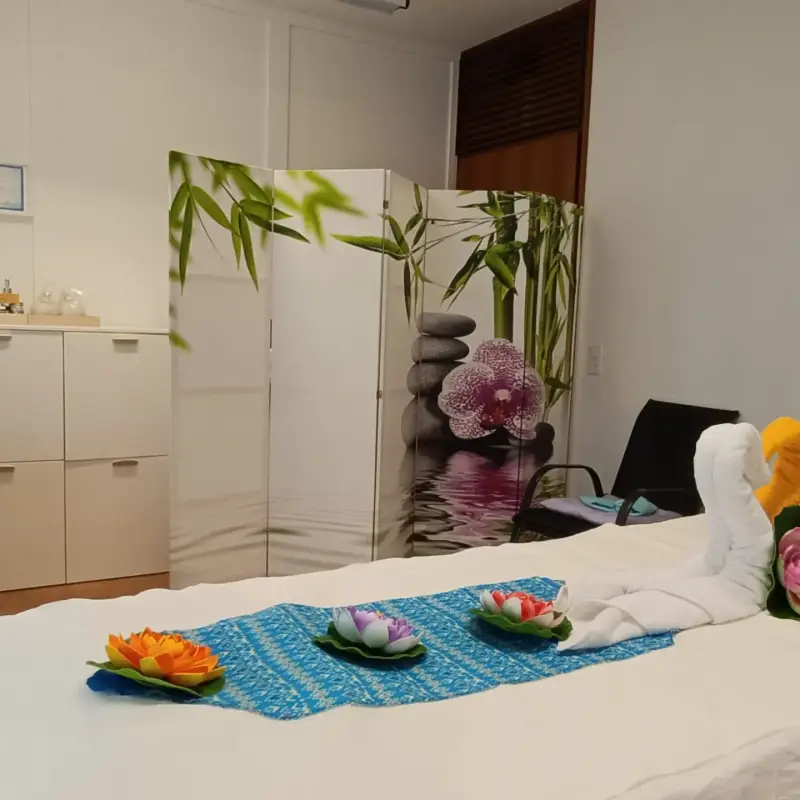 Inquadratura totale dello studio con lettino, mobile, paravento e decorazioni di fiori  