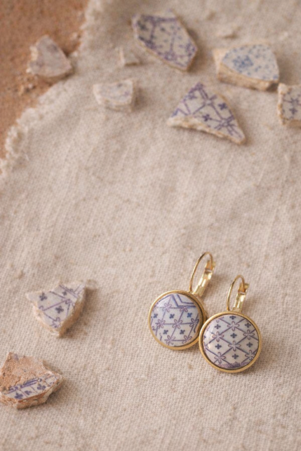 Boucles d’oreilles créées à partir d’un fragment de vaisselle ancienne transformée en bijou artisanal.
