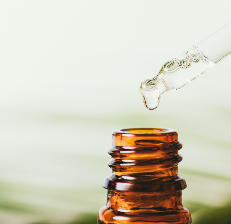 Huile essentielle d’encens avec résine dorée – flacon ambré sur fond boisé.