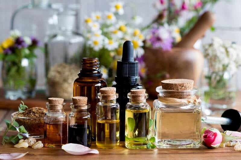 flacon d’huile essentielle de fleur d’oranger posé sur fleurs blanches – parfum délicat & sérénité