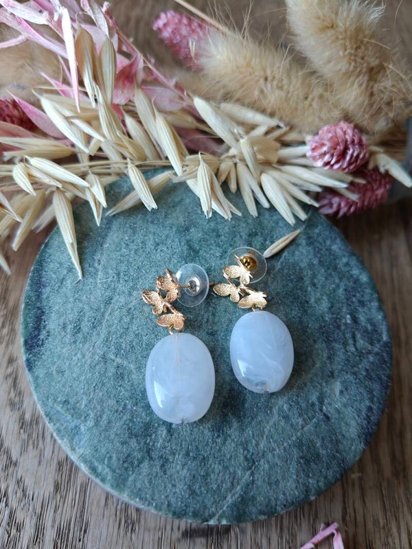 Oorbel: witte hanger met gouden vlinder prikker