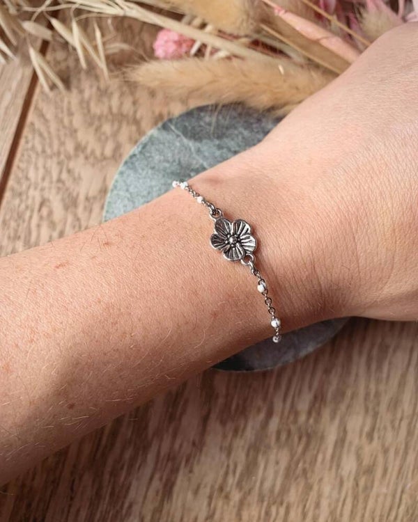 Zilveren armband met witte steentjes en bloem
