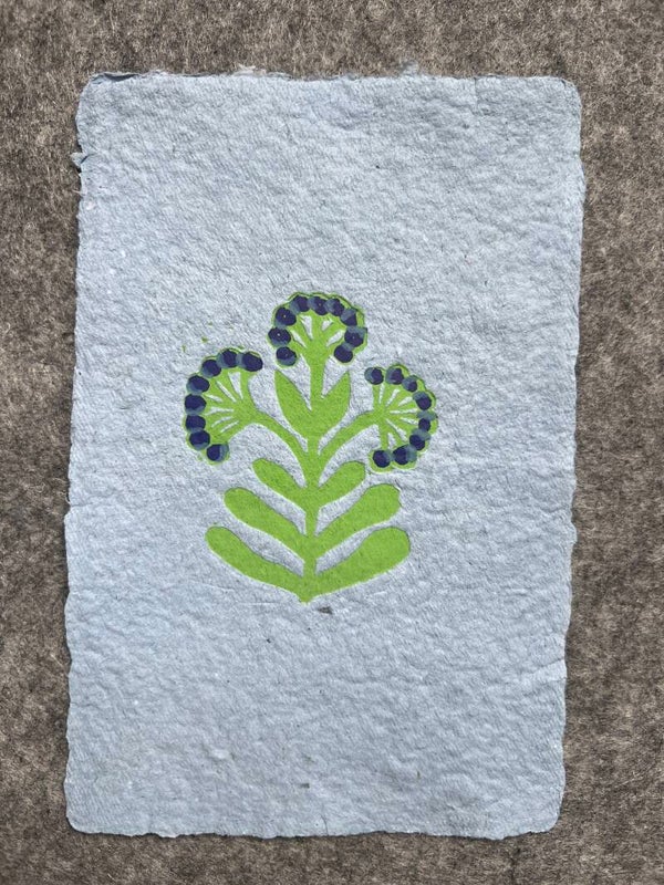 Kleine linoprint art deco stijl bloem op blauw handgeschept papier