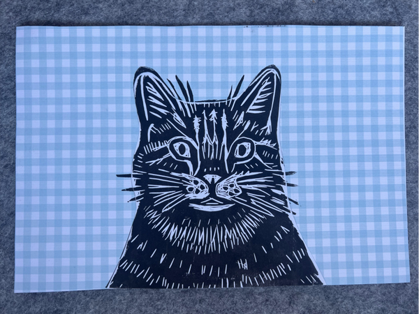 linoprint kattekop op geblokt papier