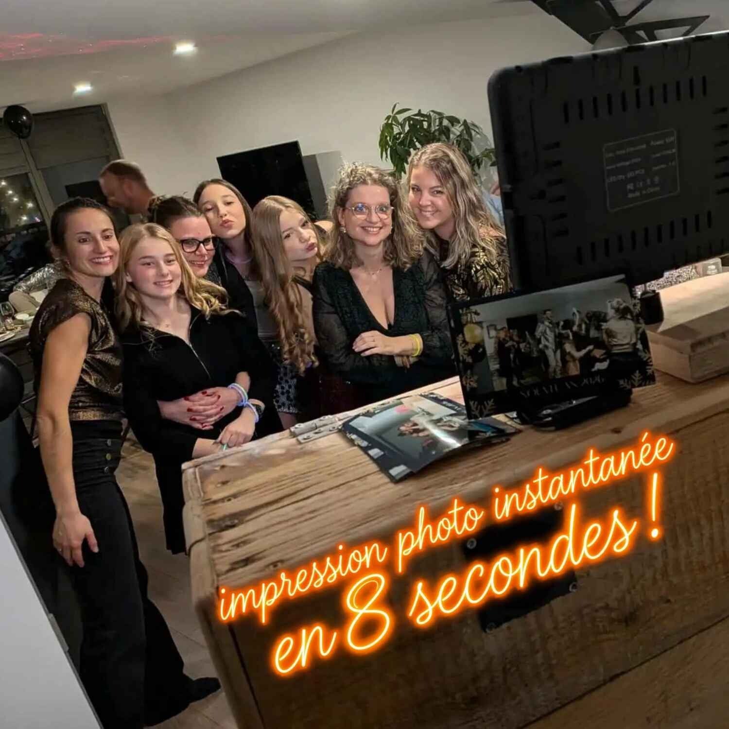 Un groupe d’invitées pose devant la borne photo vintage en bois de Photobooth54, avec impression instantanée en 8 secondes.