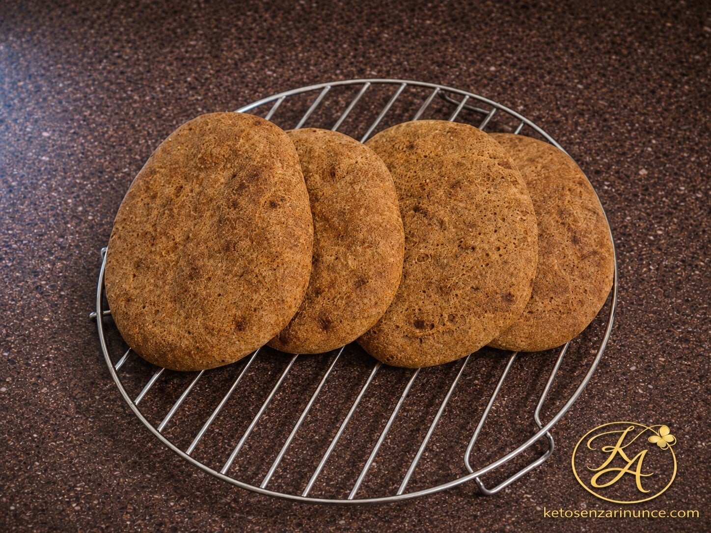 Ciabatte keto semplici appena cotte, lasciate raffreddare su una griglia. Una ricetta chetogenica rustica, leggera e versatile, preparata con farina di mandorle, fibra di avena e psillio, perfetta da farcire per pranzo, cena o colazione salata.