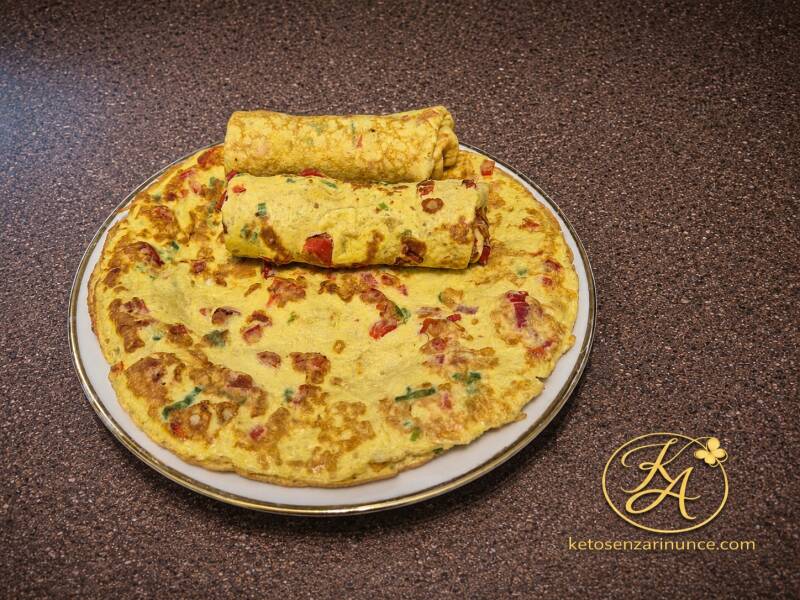 Crêpes-piadine chetogeniche morbide e saporite, preparate con peperone rosso, cipollotto ed erbe aromatiche. Una ricetta estiva, leggera e ricca di gusto, perfetta da gustare al naturale oppure farcita con carne, formaggi o verdure. Ideali per pranzo, cen