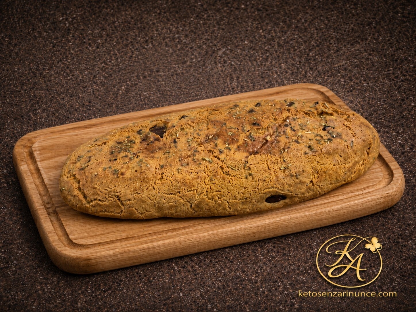Due filoncini keto alla crescenza con olive taggiasche e pistacchi, serviti su un elegante tagliere in legno. Pane rustico, morbido all’interno e con una crosta dorata, preparato con farina di mandorle e lino.