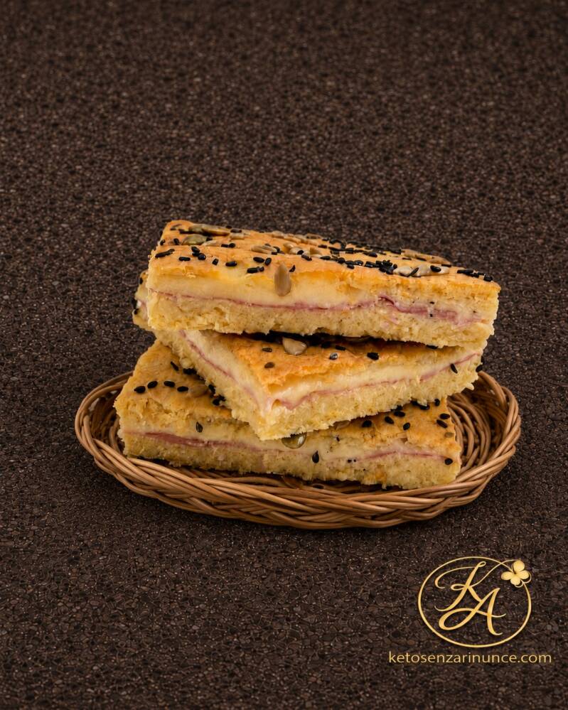 Focaccia ripiena al forno alla mozzarella con prosciutto cotto e scamorza, morbida, saporita e tagliabile a pezzi. Una preparazione chetogenica pratica e versatile, ideale per schiscette, picnic, mare, montagna o pasti fuori casa.