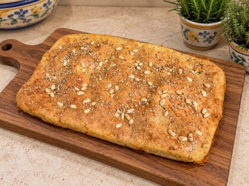 Focaccia salata keto al mascarpone con pinoli e sesamo, morbida e saporita, presentata intera su tagliere in stile mediterraneo. Ricetta chetogenica antispreco con albumi, ideale per colazione, merenda o spuntino salato. Keto senza rinunce – Keto Amica Ox