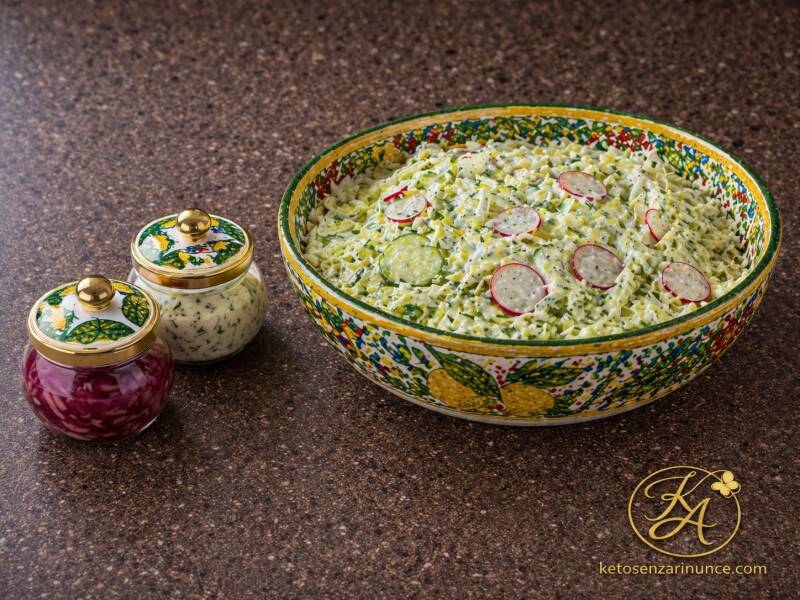 Insalata fresca di cavolo cappuccio con cetriolo e ravanelli, servita con salsa cremosa alle erbe e cipolla rossa marinata.