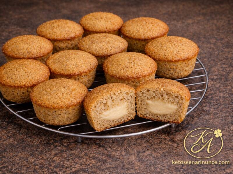 Muffin chetogenici alla nocciola con cuore cremoso, preparati con farina di nocciole e pochissima farina di mandorle. Foto con muffin interi e muffin tagliato, perfetta per presentare la consistenza morbida e il ripieno cremoso della ricetta.