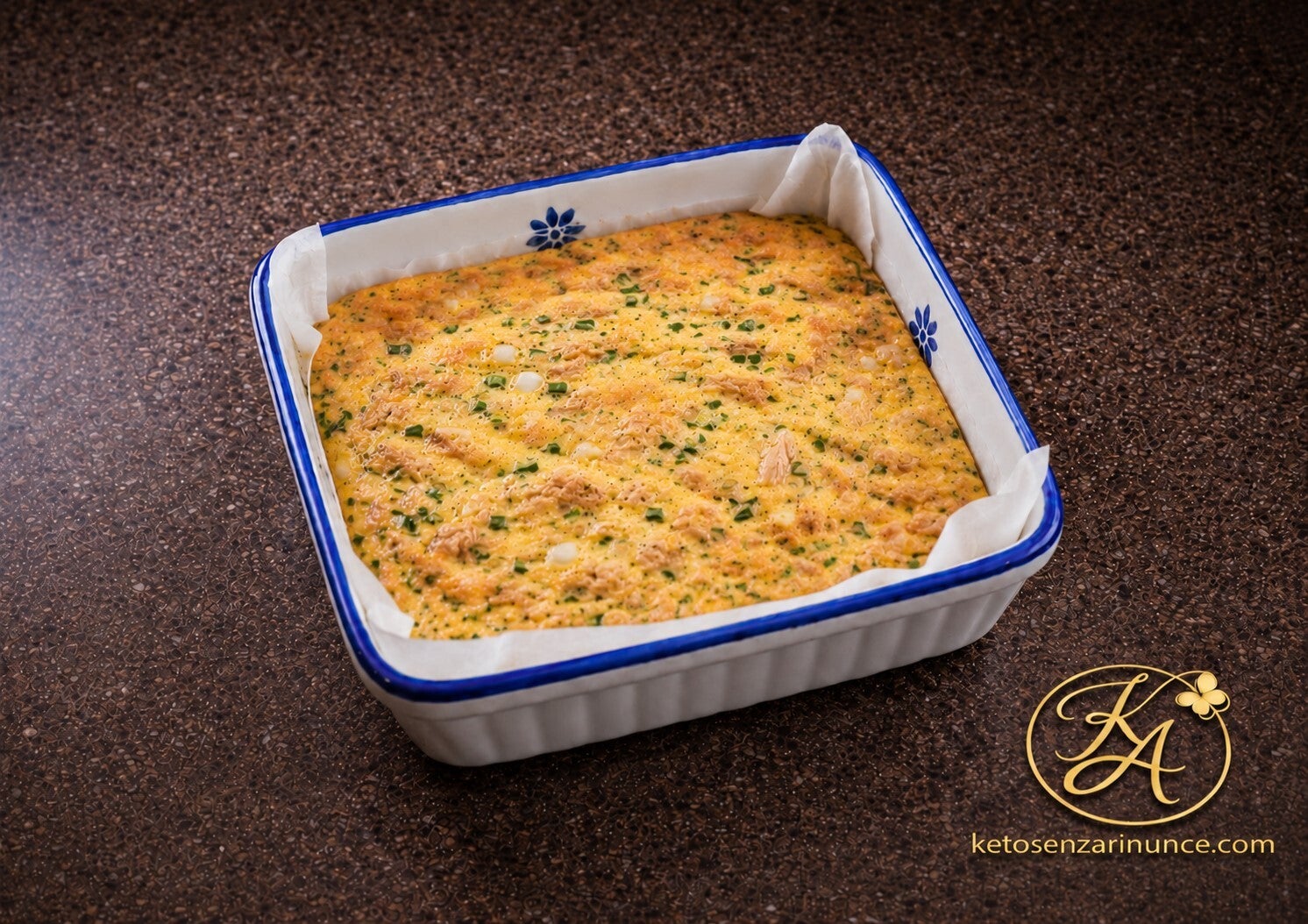 Omelette chetogenica al forno con tonno sbriciolato, cipolla ed erba cipollina, preparata nella teglia monoporzione da 15 × 15 cm rivestita con carta forno.