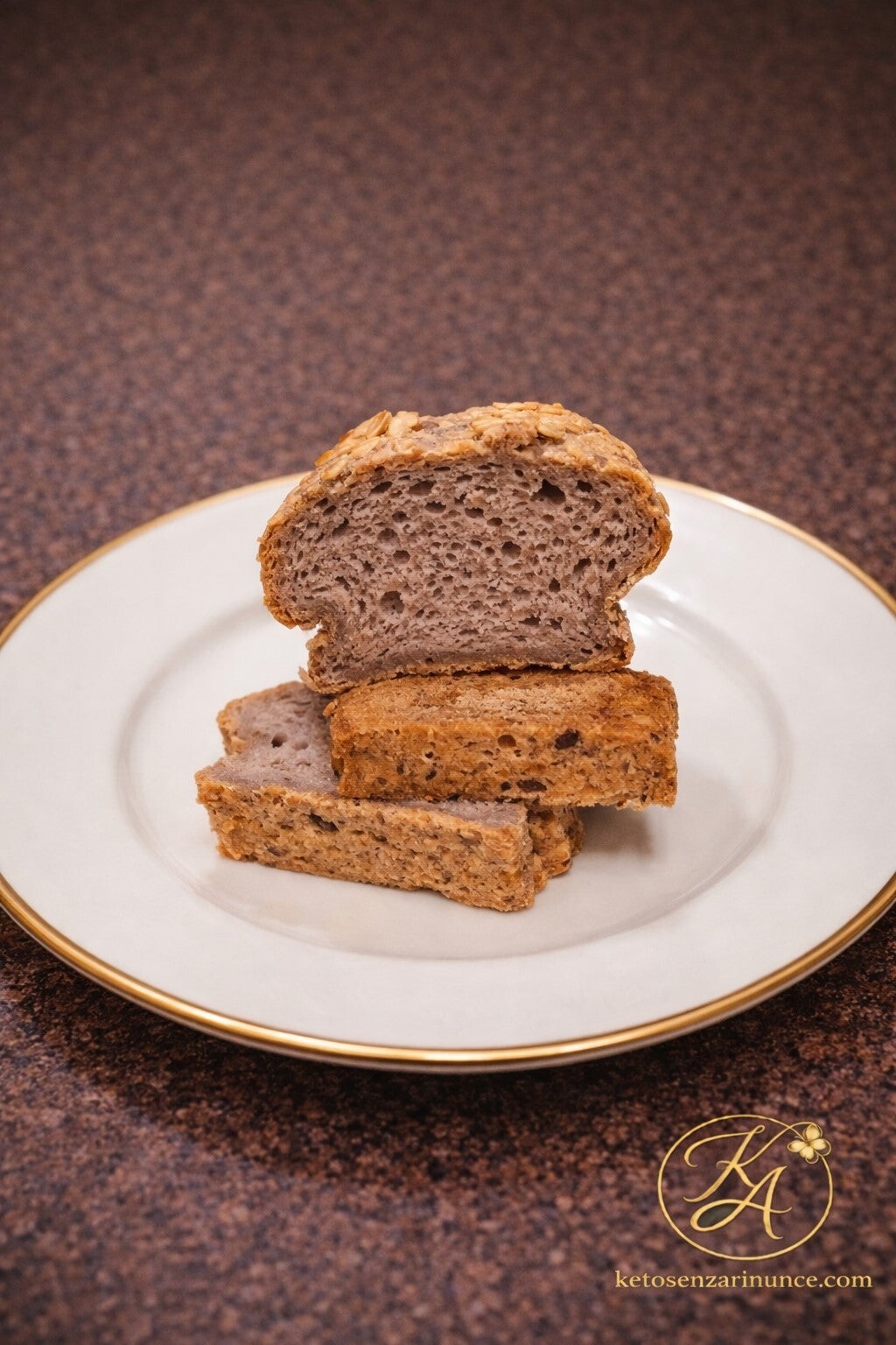 fette di pane chetogenico con interno soffice e alveolato, su piatto bianco elegante con bordo oro
