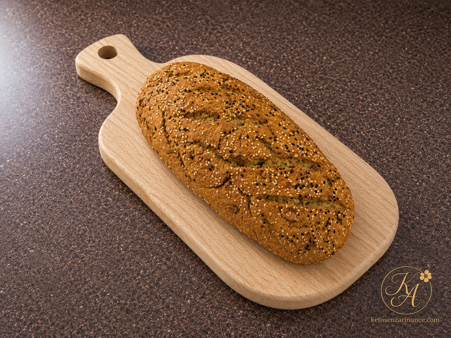 Pane chetogenico alle noci in versione rustica, fotografato su sfondo blog marrone con logo KA dorato, per il blog ketosenzarinunce.com.