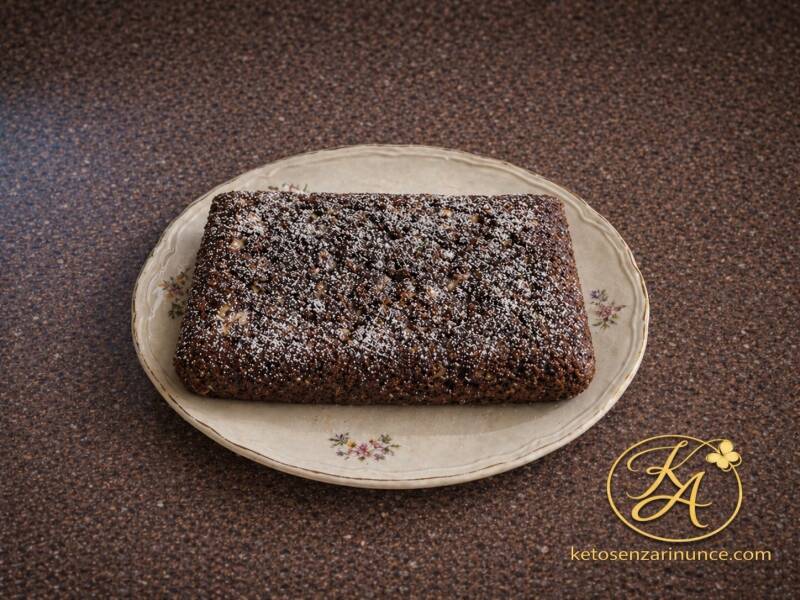 Torta al cacao e nocciola su piatto decorato, con sfondo blog marrone speckled e logo Keto Senza Rinunce.