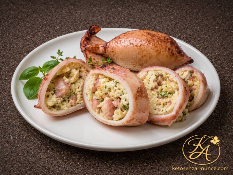 Totani ripieni estivi keto con uova sode ed erbe aromatiche, serviti interi e tagliati a fette su piatto bianco elegante, con ripieno morbido e profumato ben visibile. Immagine raffinata per il blog Keto senza rinunce, su sfondo marrone speckled con logo 