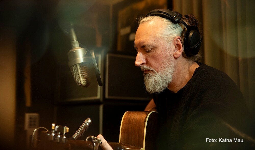 Finian Greenall alias Fink mit Gitarre un Aufnahmemikrofon im Tonstudio