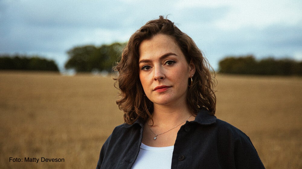 Katherine Priddy vor einem Feld mit Bäumen im Hintergrund | Foto: Matty Deveson
