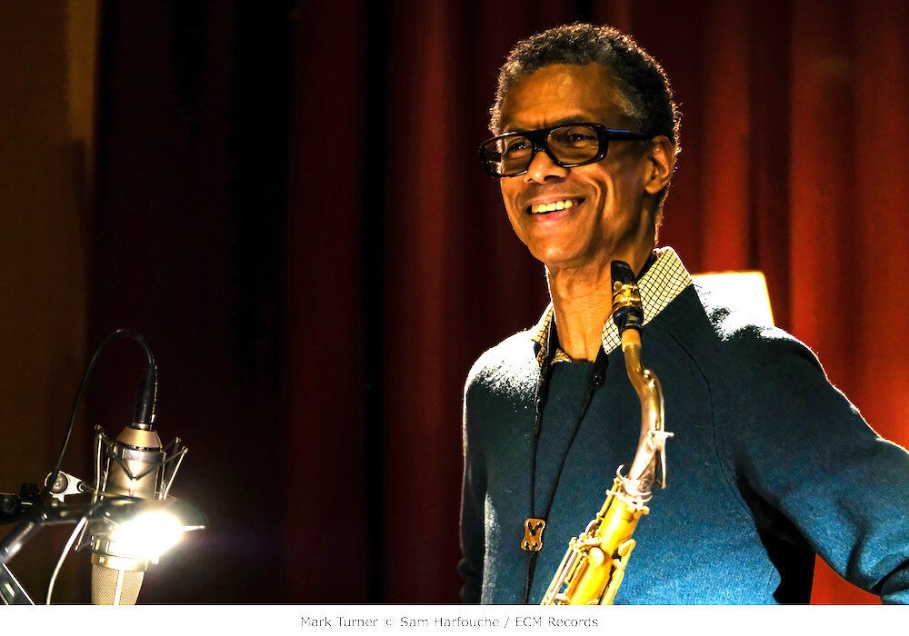 Mark Turner vor rotem Vorhang mit Saxofon und Mikrofon | Foto: Sam Harfouche / ECM Records