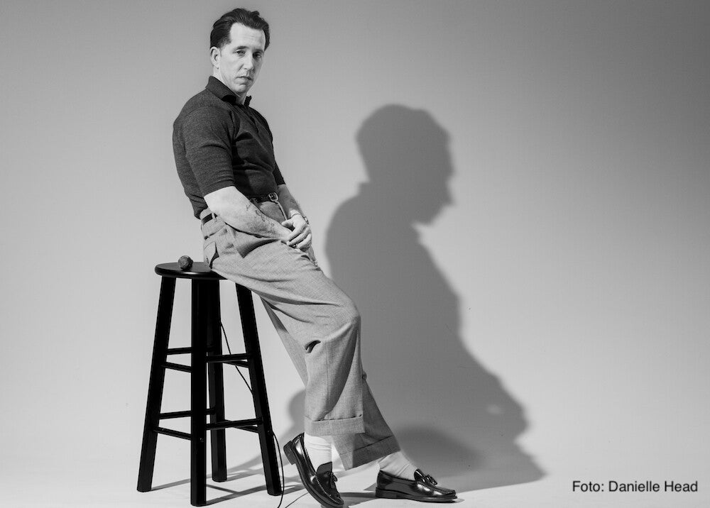 Pokey LaFarge lehnt an einem Barhocker vor grauem Hintergrund | Foto: Danielle Head