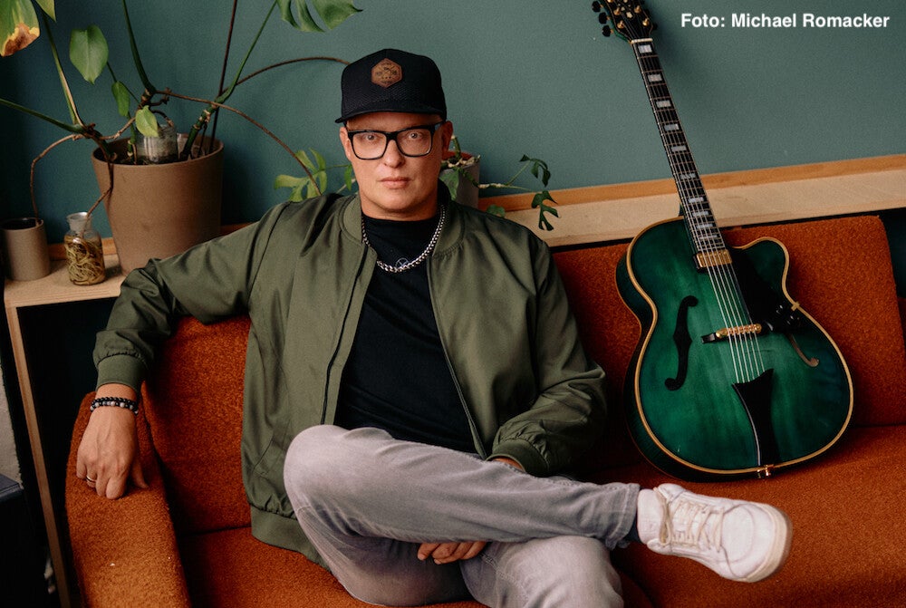 Torsten Goods auf einem roten Sofa mit Gitarre | Die Review zur LP "Soul Deep"  im Vinyl-Fan Blog