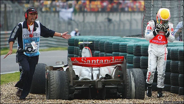 Hamilton's heartbreaking crash on pit entry in China 2007. He can be seen next to his beached McLaren looking upset with his head in his hands