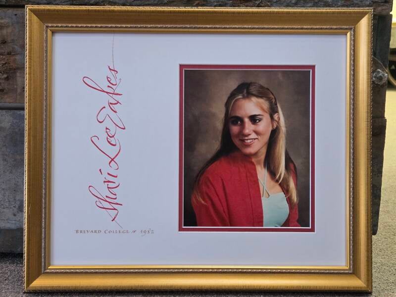 gold frame woman in red sweater custom framing calligraphy service french broad imaging asheville 