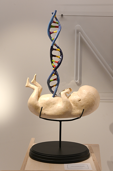 beeld van baby met navestreng op postament