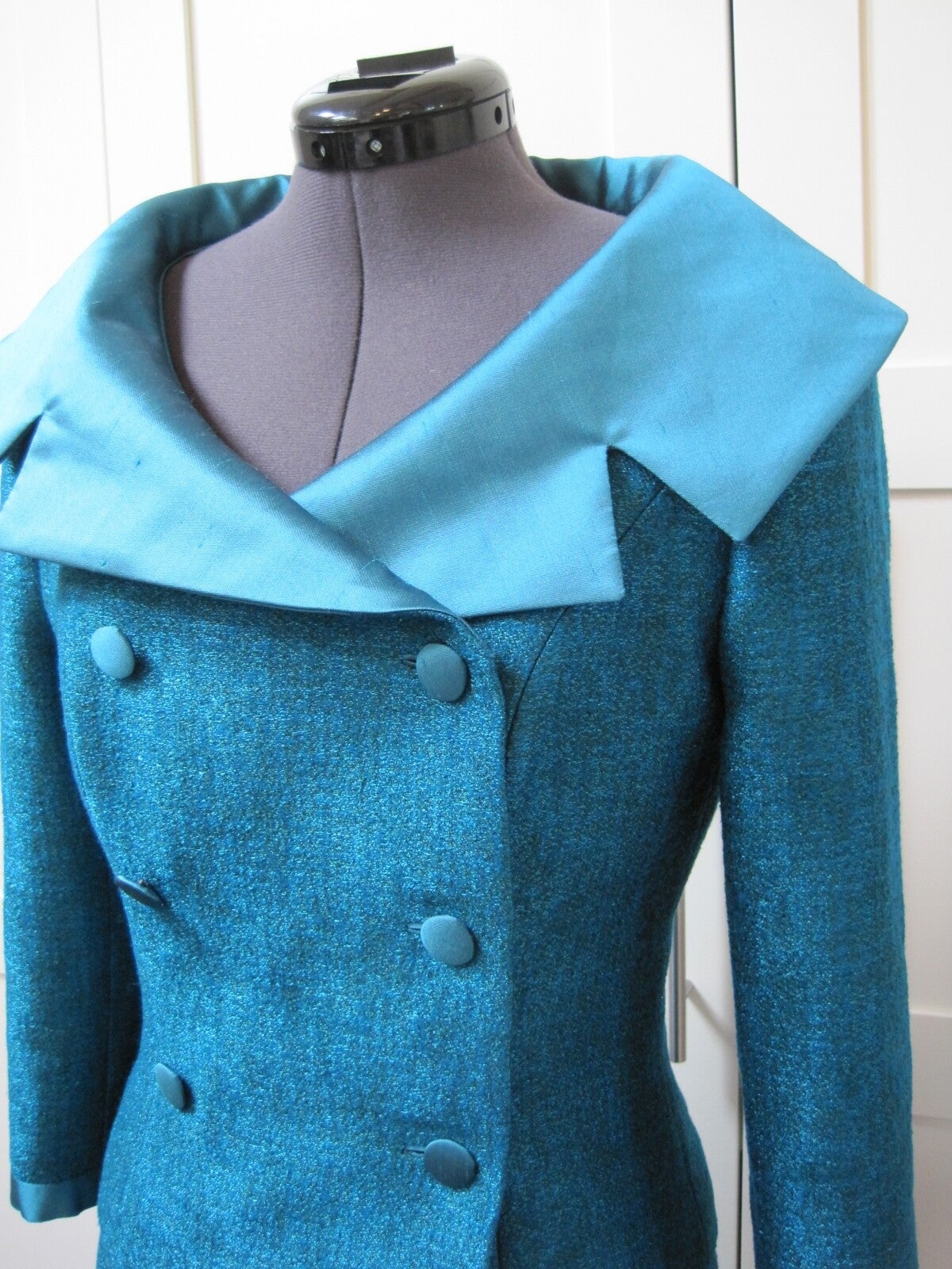 Helderblauw doublebreasted mantelpakje van een tweedachtige wollen stof met zijden details. Maatwerk van Modestudio Jacoba.