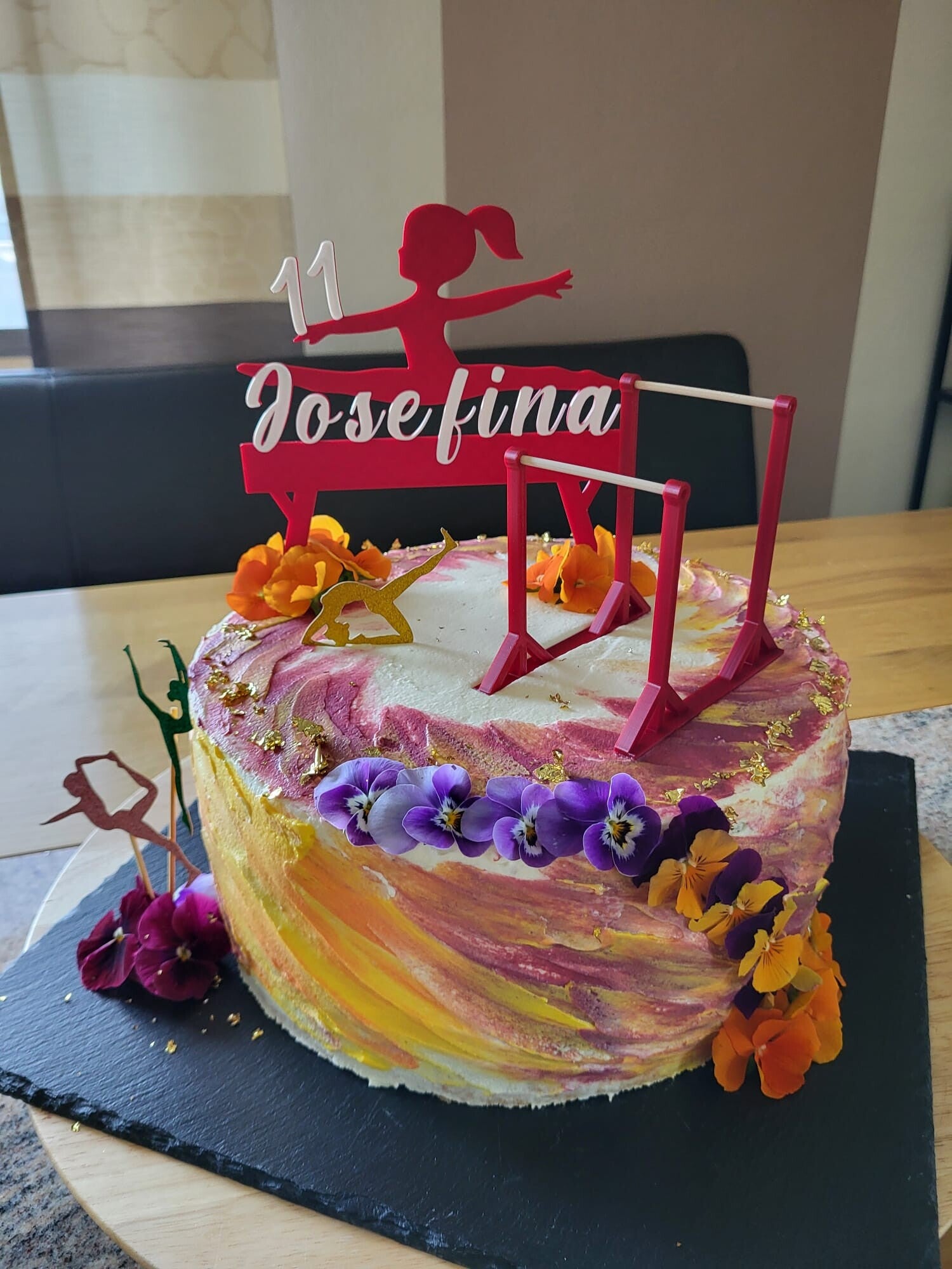 Geburtstagstorte für ein Mädchen zum 11. Geburtstag mit personalisiertem Turnen-Tortenstecker, Name Josefina, Turnerin-Silhouette, Barren-Deko und bunten Blüten