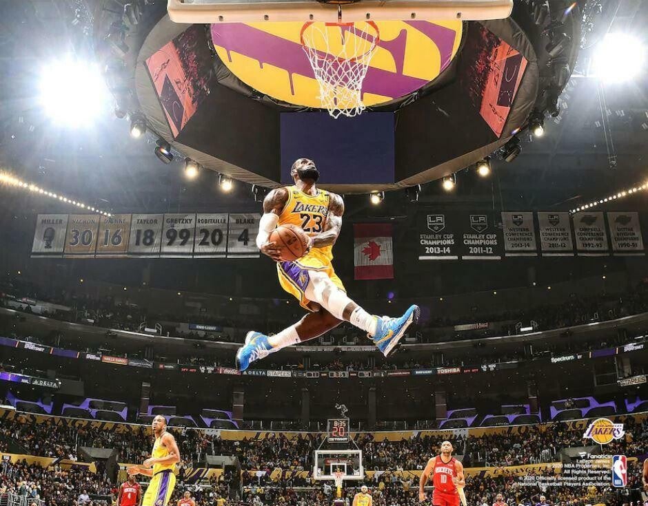 un joueur de basket (Lebron James) en plein saut pour faire un dunk sur un terrain de basket