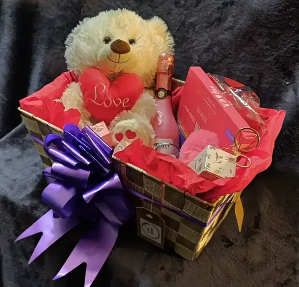 Cesta de regalo con variedad de productos y envoltorio incluido.