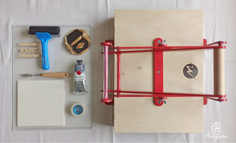 Kit linogravure pour créer une estampe composé de : une presse manuelle, un baren japonais, un rouleau de la marque Essdee, un tube d'encre Caligo Safe wash relief ink de Cranfield, un couteau à peindre, des épingles à linge, des feuilles à imprimer, du s