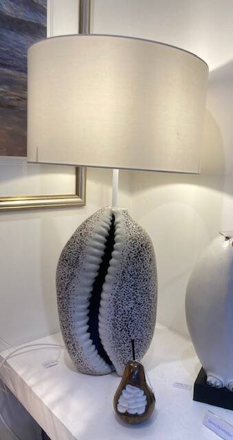 Cowrie shell lamp with spotted decoration to base plus small ceramic gunmetal finish glazed pear sculpture with bite taken out of it