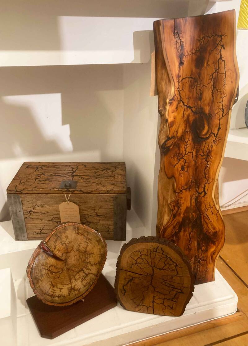Photo of four pieces of wooden artwork - a large cedar wall hanging, an Oak box and two ornamental oak discs.