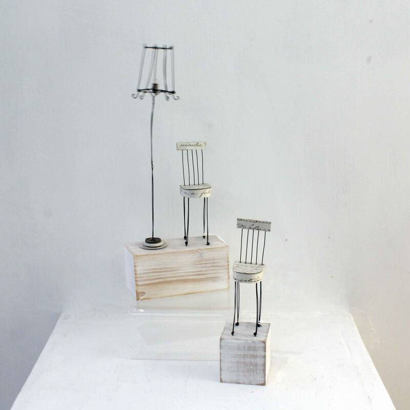 Two delicate small wire sculptures by Sarah Jane Brown - one of a paper & wire dining chair next to a wire standard lamp on a block of wood, the other a single dining chair on a wooden base
