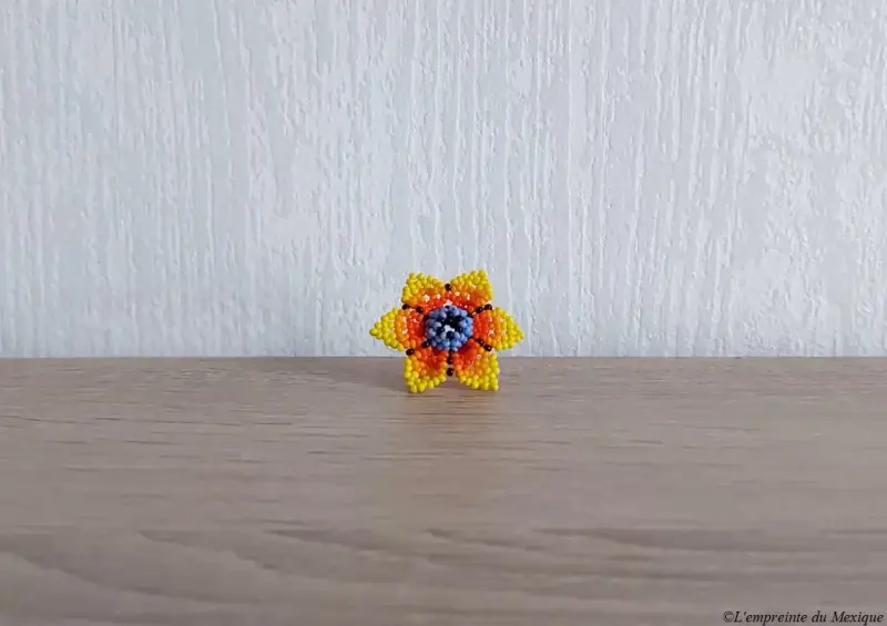 Bague en perles de chaquiras représentant une fleur de peyotl jaune tissée à la main par Elvia Gonzalez Carrillo et sa famille, artisans de la communauté autochtone Wixarika (Huichol) à Tepic, Nayarit (Mexique)