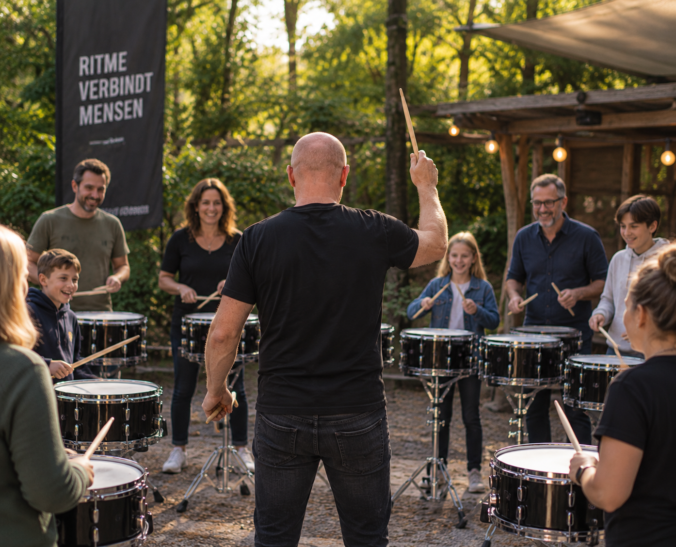 Sfeerbeeld van een begeleider die een open trommelworkshop in de buitenlucht verzorgt