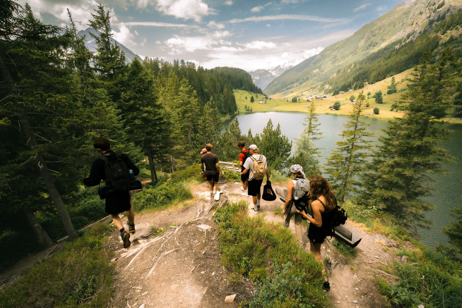 Small group hiking beside an Alpine lake in Switzerland
