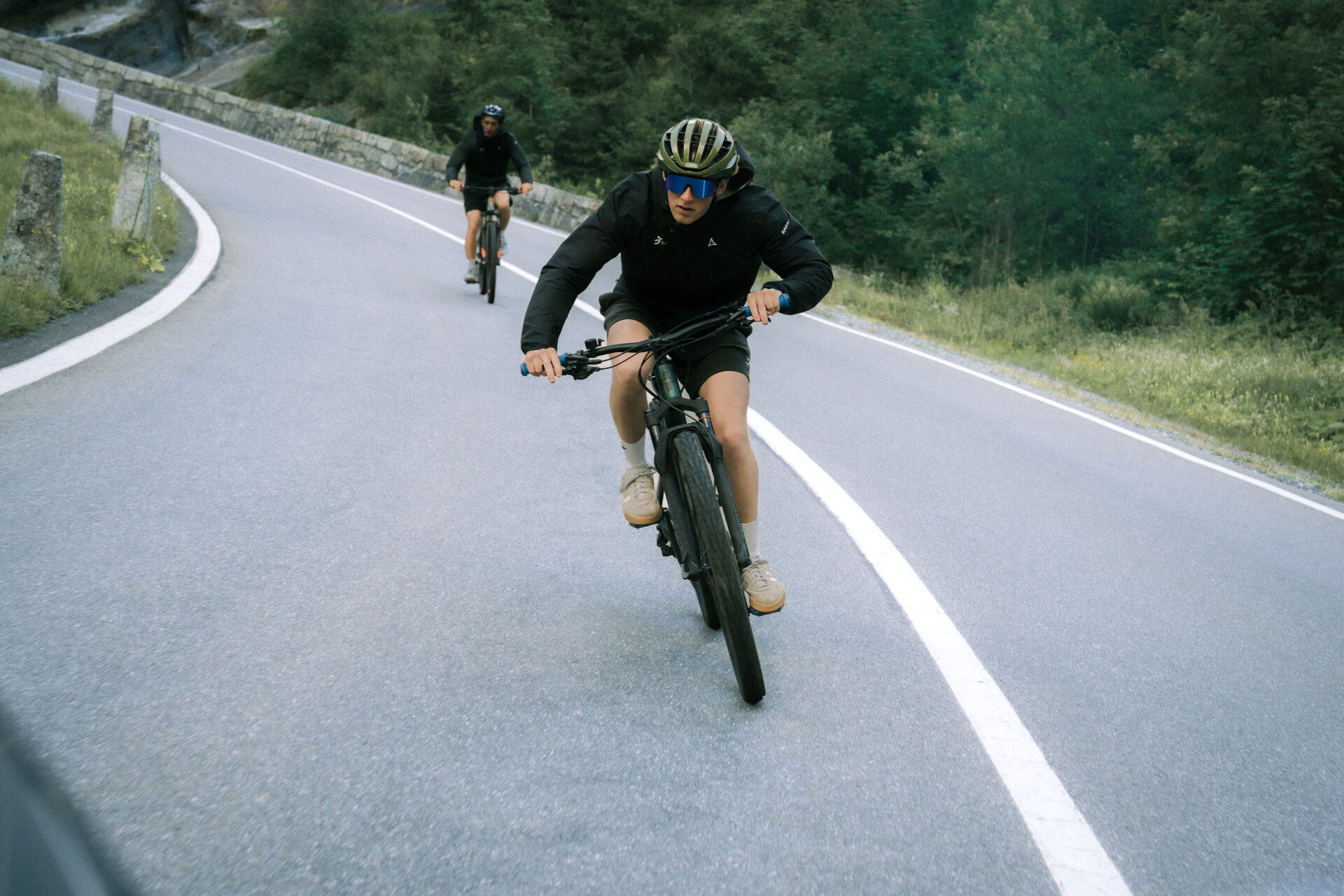 Cyclists climbing a scenic Swiss mountain road
