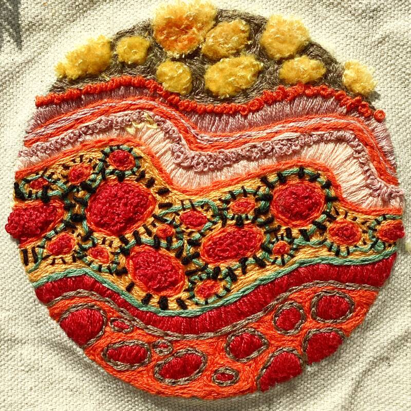 Small abstract hand embroidered artwork featuring varied textures achieved by French knots, buillon stitch, couching, turkey stitch and satin stitch