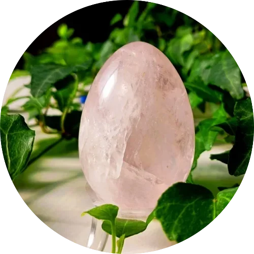 Huevo yoni de cuarzo rosa sobre musgo, reconexión íntima
