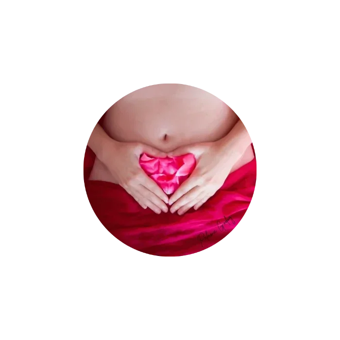 Manos formando un corazón sobre el vientre de una mujer, naturaleza femenina